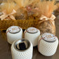 "Four compact resin Oud holders on a table, one with the lid open, displaying intricate designs by Hyacinth Resin arts."