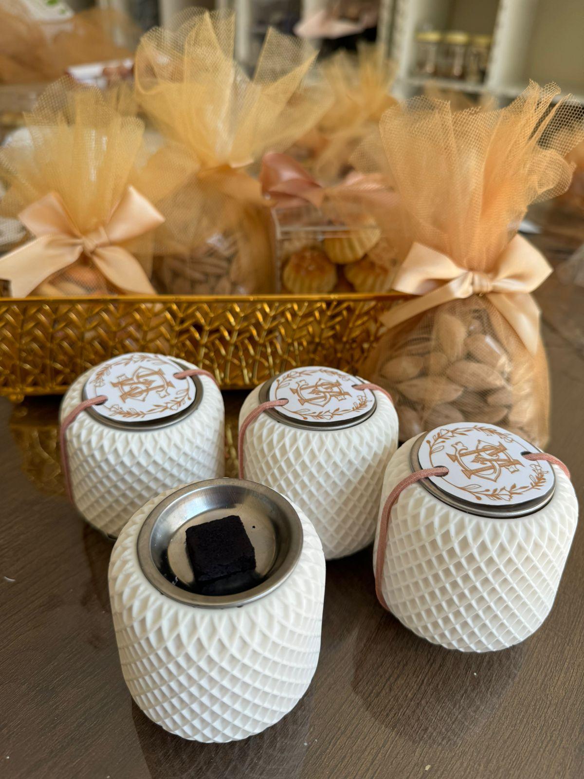 "Four compact resin Oud holders on a table, one with the lid open, displaying intricate designs by Hyacinth Resin arts."