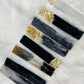 Top view of multiple geode-themed resin bookmarks arranged on a soft, feather-like surface, showcasing intricate patterns, vibrant colors, and glossy epoxy finishes.






