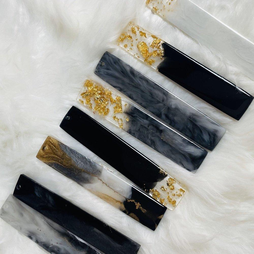 Top view of multiple geode-themed resin bookmarks arranged on a soft, feather-like surface, showcasing intricate patterns, vibrant colors, and glossy epoxy finishes.






