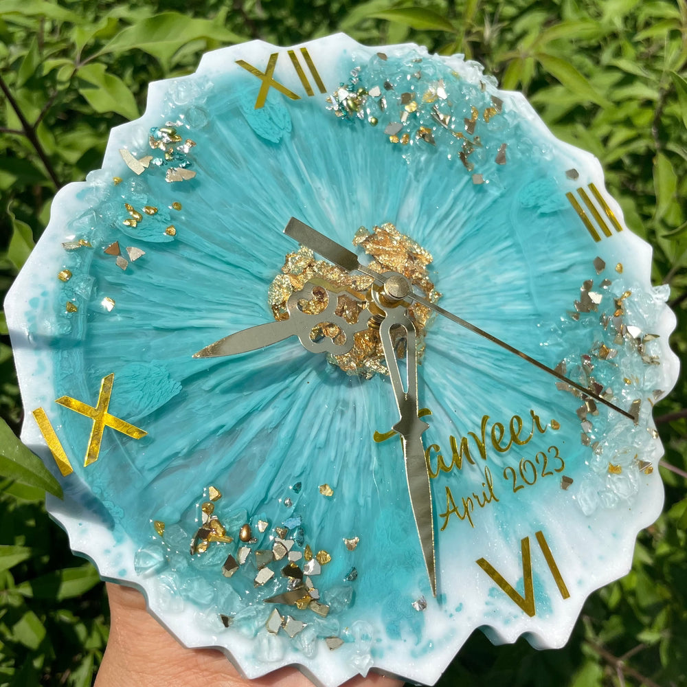 "Top view of an ocean-themed resin clock featuring waves and blue hues, set against a grass-themed background."